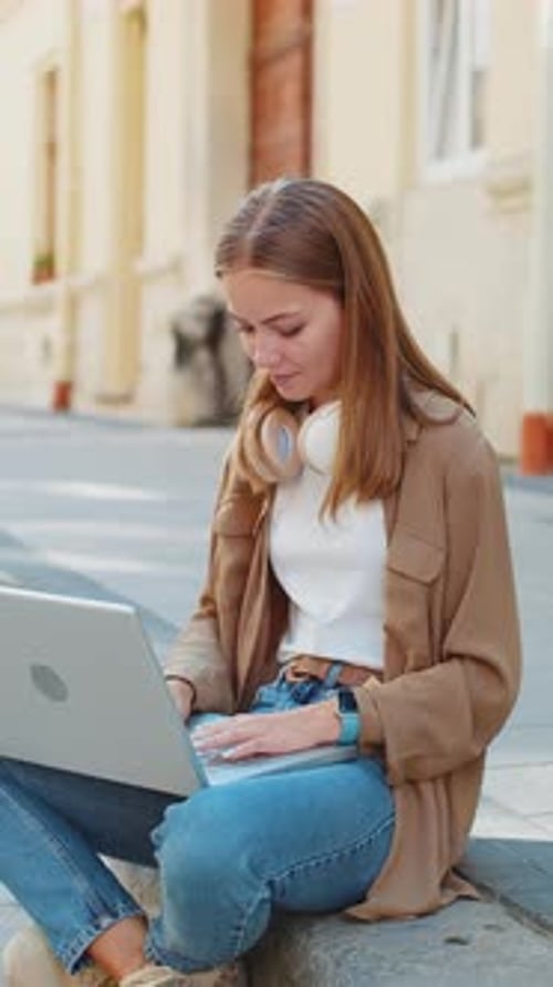Caucasian Young Woman Freelancer Sitting on Street Using Laptop Working Online Distant Job Outdoors