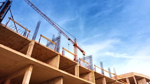 Construcción de un edificio de varios pisos con armadura metálica en la parte superior.