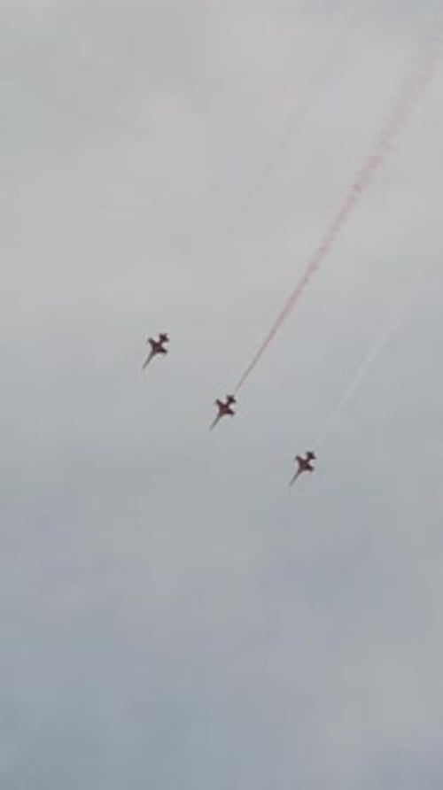 Vertical video. An airshow with fighter jets flying close together at the same speed.