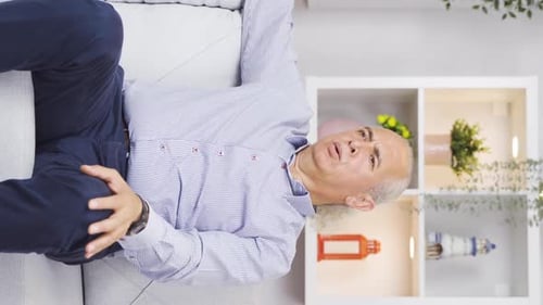 Vertical video of Depressed old man is home alone and nervous.