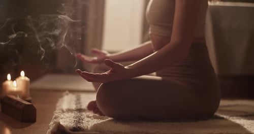 Female Meditating Near Tea and Incense