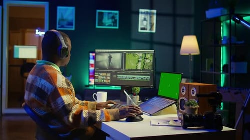 Videographer Creating Visual Effects on Montage Next to Green Screen