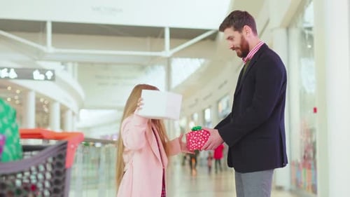 Father and His Daughter Exchanging Christmas Present Boxes Gifts on Shopping Center Talk Dad Child