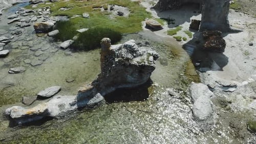 Aerial view of rock formations on land and in water at sea coast