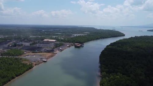 The process of loading coal onto a barge using a transport truck