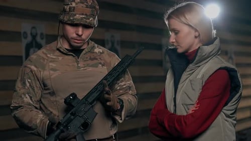 Close Up At a Professional Shooting Range Military Trainer Tells a Girl How to Properly Handle NATO