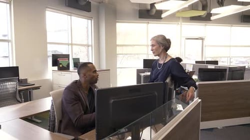 Mature business colleagues discuss strategy in modern creative office