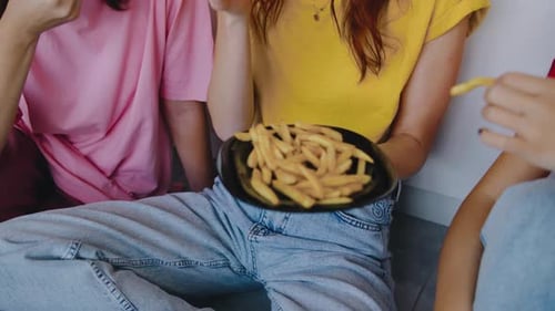 Friends Eating Fries and Chatting Together Indoors