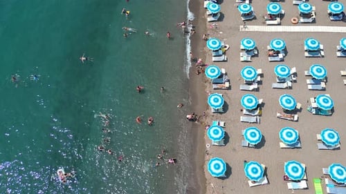 Flying a Drone Along a Beach on the Mediterranean Coast and Beach Umbrellas Standing on the Beach