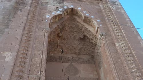 Nous voyons la porte principale de la madrasah de Zinciriye, faite de magnifiques pierres, du bas vers le haut