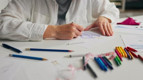Woman sketching design on paper in a studio
