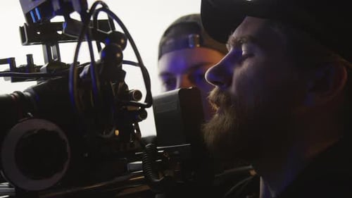 Videographer and Assistant Shooting Footage in Studio
