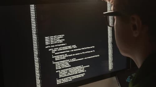 Close-Up of a Young Man Coding on a Computer at Night