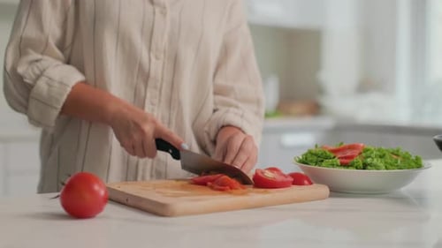 Tomatoes Sliced by Person at Kitchen Counter