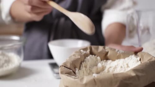 Scooping Flour with Wooden Spoon for Baking