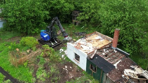 Excavator Demolishing Old Building in Rural Area