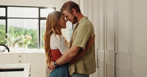 Loving Couple Embracing in Bright Indoor Kitchen