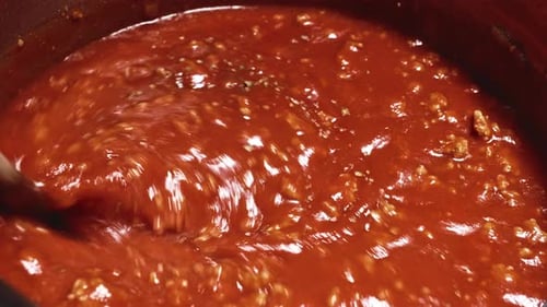 Red Sauce Simmering in a Pot Being Stirred