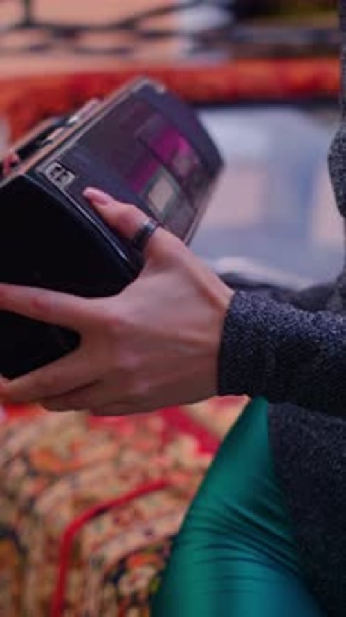 Fille tenant une boombox musicale, présentant la technologie rétro et son utilisation dans le monde moderne.