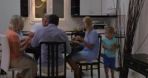Family Together Eating Watermelon in Modern Kitchen