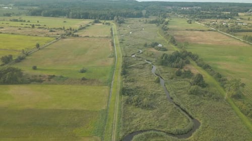 The Beautiful Scenery Of Wide Green Field In Debki, Poland During Sunny Day - Aerial Shot