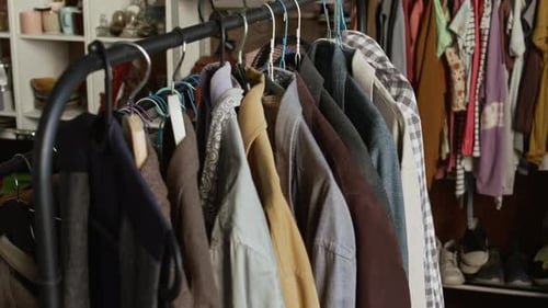 Preowned Menswear Garments Arranged on Hangers in Second Hand Outlet