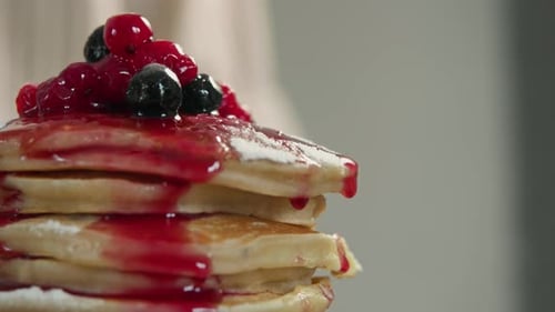 Pancakes with Blueberries and Cranberries Stacked High and Dripping with a Sweet and Juicy Jam Close