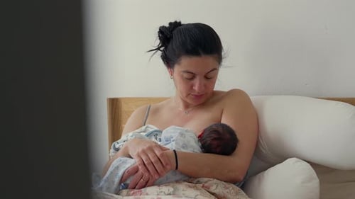 Woman Holding Newborn Baby Indoors