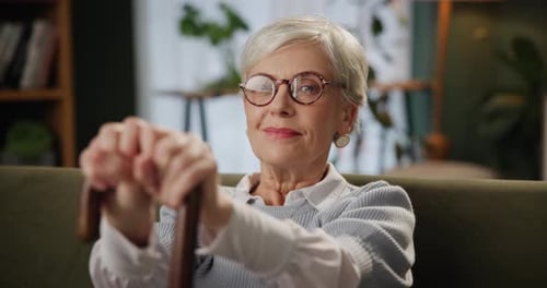 Smiling Silver Haired Woman Holding Cane Indoors
