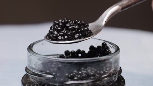 Black Caviar in Glass Pot Closeup Beluga Sturgeon Salted Roe in Glass Bowl Raw Seafood Luxury