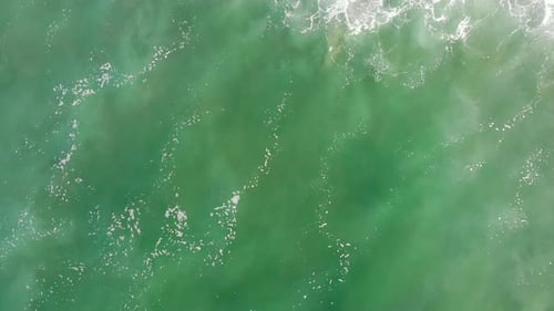Overhead aerial 4k drone of surfer in waves wiping out at Huntington Beach, Pacific Ocean, Californi