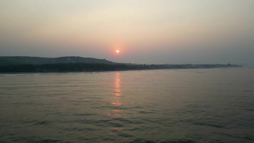 Golden Sun Sets Behind Forested Indian Coastline and Ocean