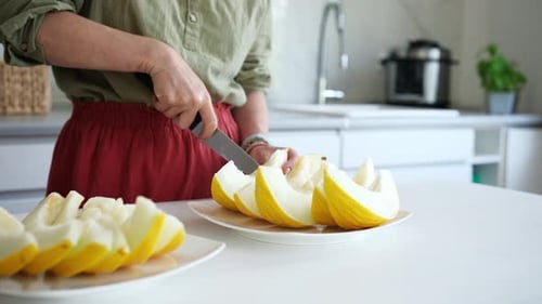 Frau schneidet Melone in Stücke