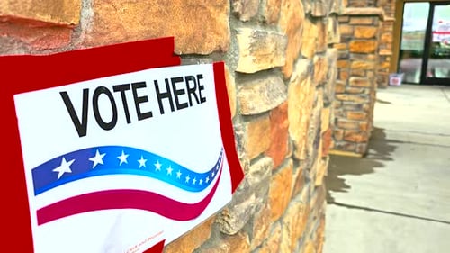 Close-Up of Vote Here Sign Symbolizing Democracy and Voting Rights