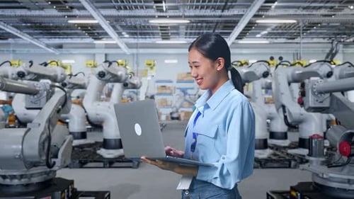 Woman with Laptop in Robotics Factory