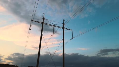 Dark Silhouette of High Voltage Tower with Electric Power Lines at Sunset Transfer of Electricity