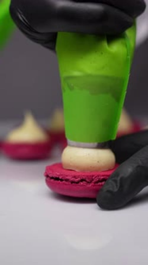 Delicate Macaron Being Filled with Cream Filling