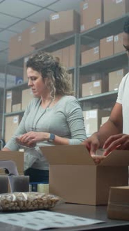 Multiethnic Postal Workers Packing Cardboard Boxes Preparing Parcels for Shipping