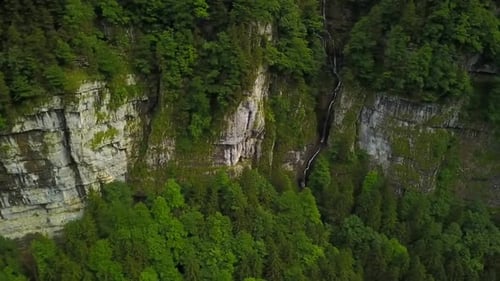 Dramatic Aerial View of Cliff Face with Waterfall