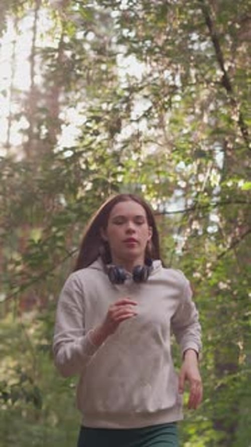 Young Woman Athlete Jogging in Forest
