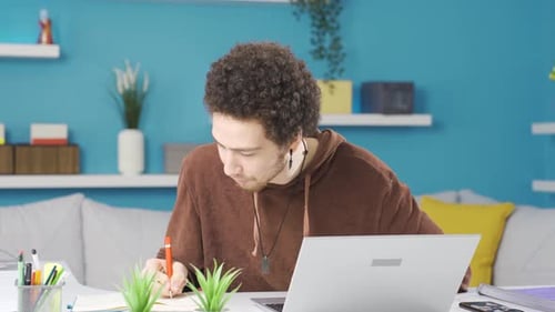 Young Adult Writing at Desk at Home