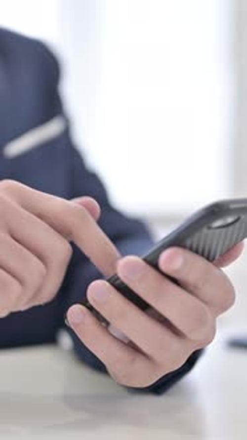 Man in Suit Using Mobile Phone at Desk