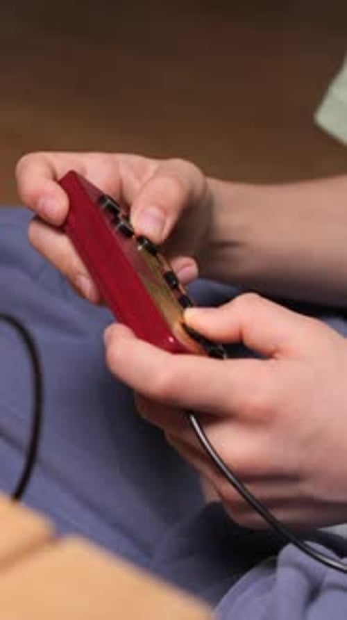 Hands Operate a Retro Video Game Console