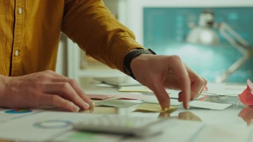 Man Hands Sorts Colorful Notes on Desk