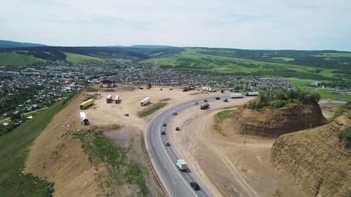 an Intercity Highway with Traffic and View Point with Parking on a Roadside and a Village Down the