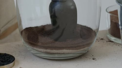 A young female botanist creates a tiny live forest ecosystem in a huge glass jar - creating the main