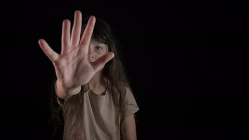 Distressed Girl Raises Hand in Stop Gesture