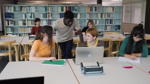 Young diverse people studying in library - School education concept
