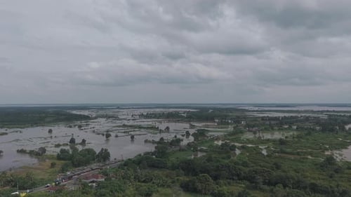 Aerial View Of A Flooded Landscape With Trees And Buildings Under A Cloudy Sky