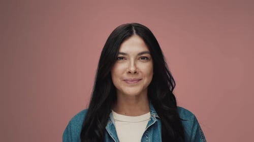 Studio Portrait of Young Woman Opening Eyes Looking at Camera and Smiling Happy